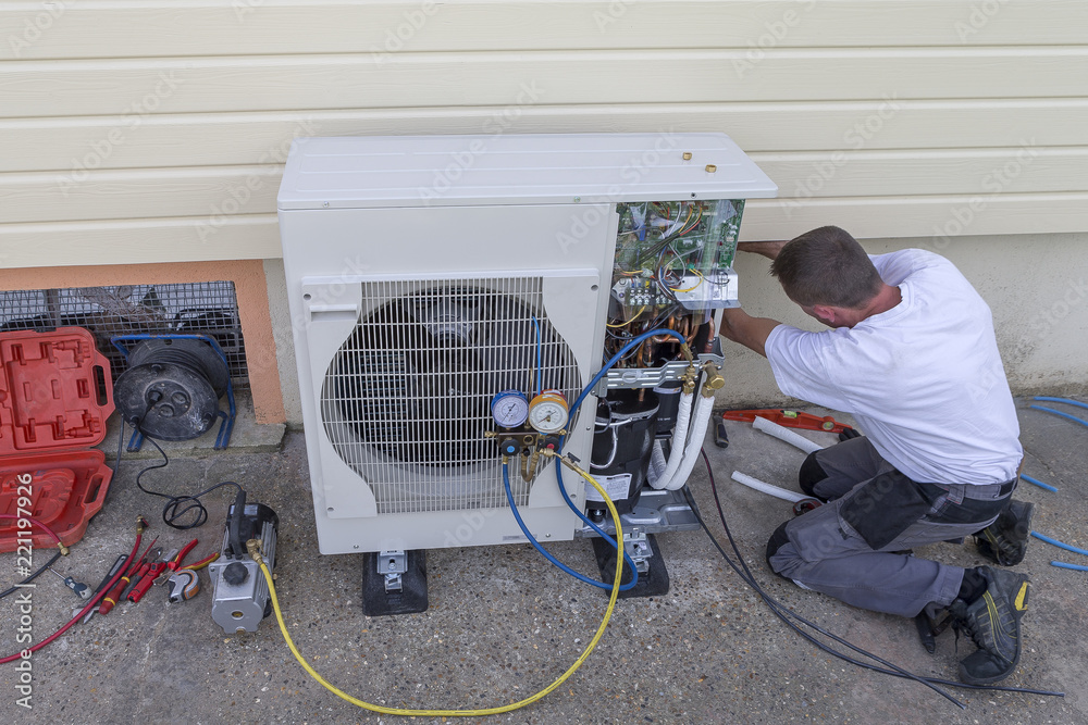 Stock photo of a man repairing heating pump
